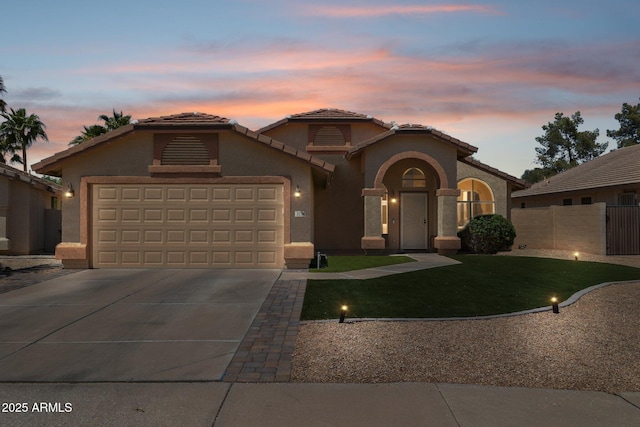mediterranean / spanish-style home featuring fence, an attached garage, a tile roof, stucco siding, and driveway