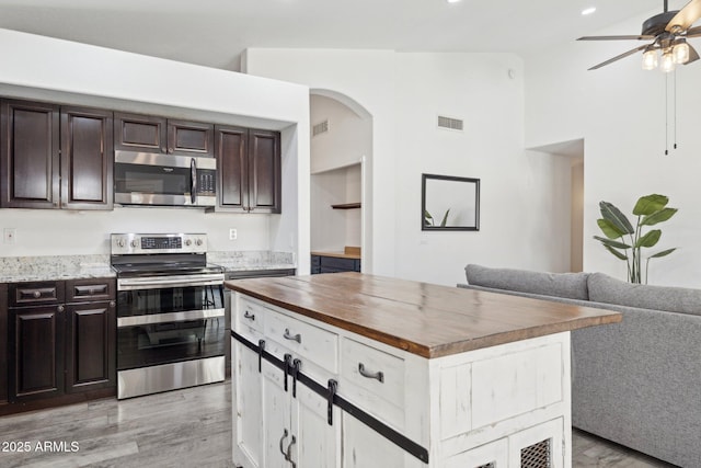 kitchen with wooden counters, stainless steel appliances, light wood-type flooring, and visible vents
