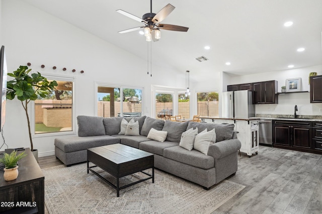 living room featuring ceiling fan, light wood-style floors, high vaulted ceiling, recessed lighting, and visible vents