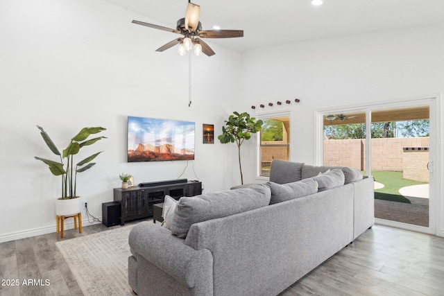 living room with ceiling fan, high vaulted ceiling, baseboards, light wood finished floors, and recessed lighting
