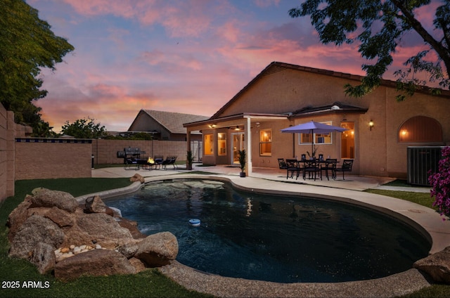 pool at dusk featuring a fenced in pool, central AC unit, a patio area, and fence