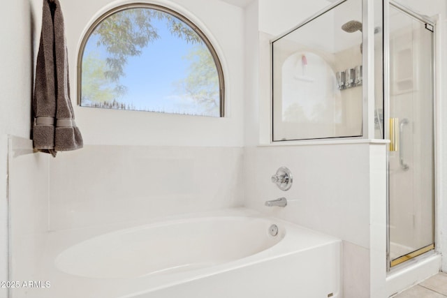 bathroom with a shower stall and a garden tub