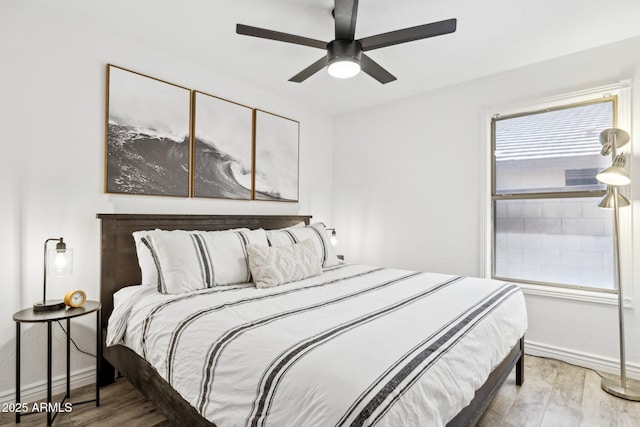 bedroom featuring baseboards, a ceiling fan, and wood finished floors