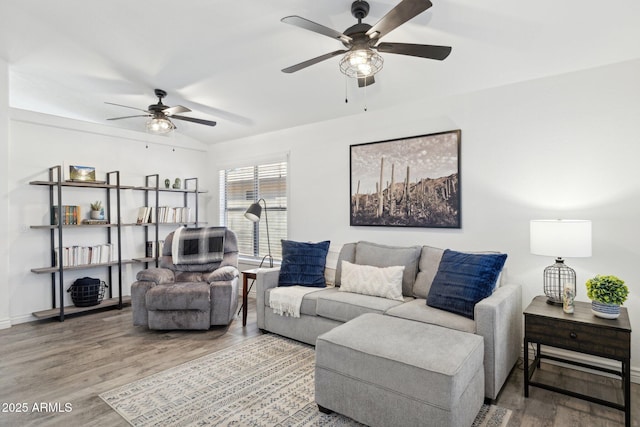 living room featuring a ceiling fan, wood finished floors, and lofted ceiling