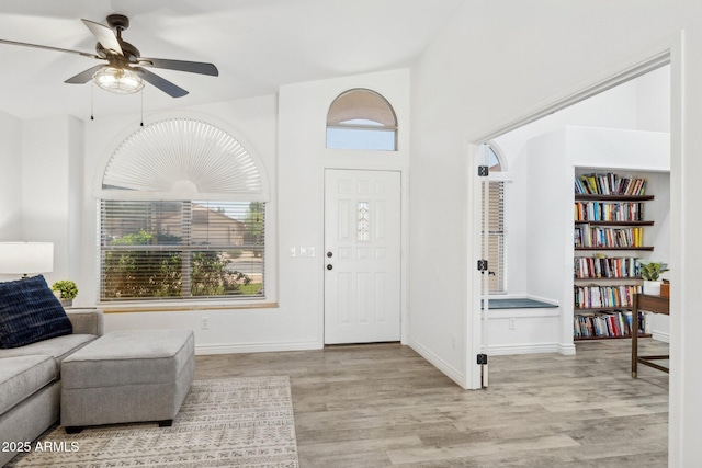 foyer featuring baseboards, ceiling fan, and wood finished floors