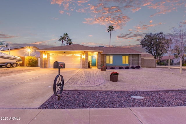 ranch-style home featuring a garage, brick siding, and driveway