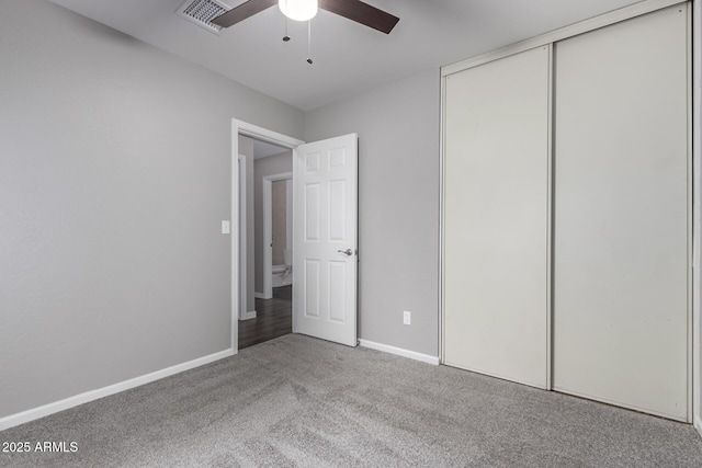 unfurnished bedroom with a closet, visible vents, baseboards, and carpet