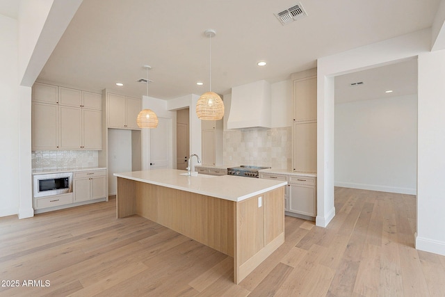 6832 N 178th Ln, Waddell, AZ 85355 - kitchen with premium range hood, visible vents, a sink, light wood finished floors, and built in microwave
