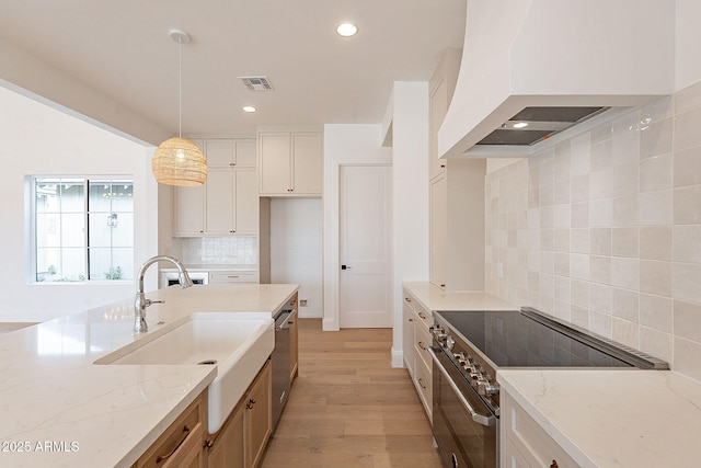 6832 N 178th Ln, Waddell, AZ 85355 - kitchen with visible vents, light stone counters, appliances with stainless steel finishes, custom exhaust hood, and a sink