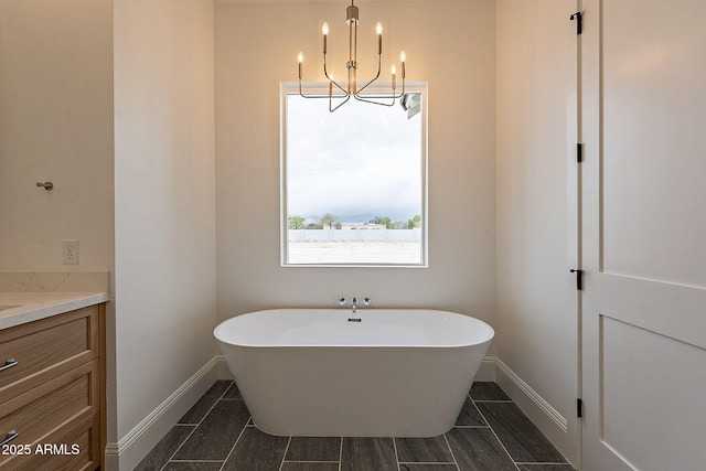 6832 N 178th Ln, Waddell, AZ 85355 - full bathroom with baseboards, vanity, an inviting chandelier, and a freestanding tub