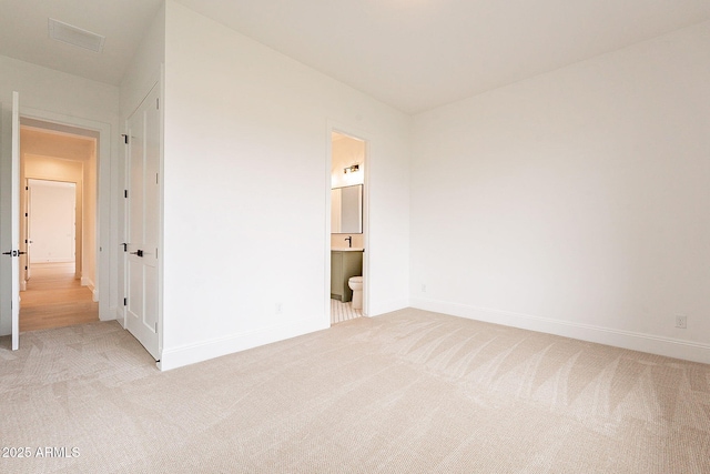 6832 N 178th Ln, Waddell, AZ 85355 - unfurnished bedroom with connected bathroom, baseboards, and light carpet