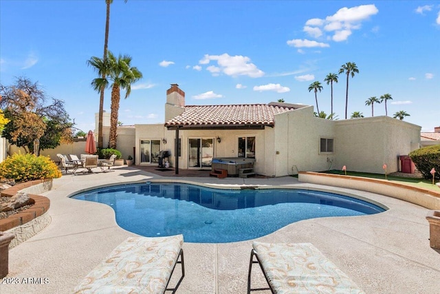 view of pool with a hot tub and a patio