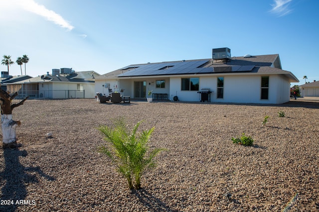 rear view of property featuring a patio, solar panels, and cooling unit