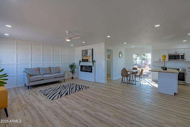 living room featuring light wood-type flooring and ceiling fan