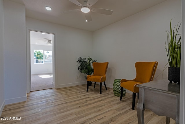 sitting room featuring light wood-type flooring and ceiling fan