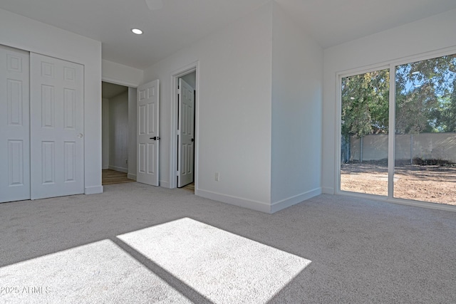 unfurnished bedroom featuring a closet and light carpet