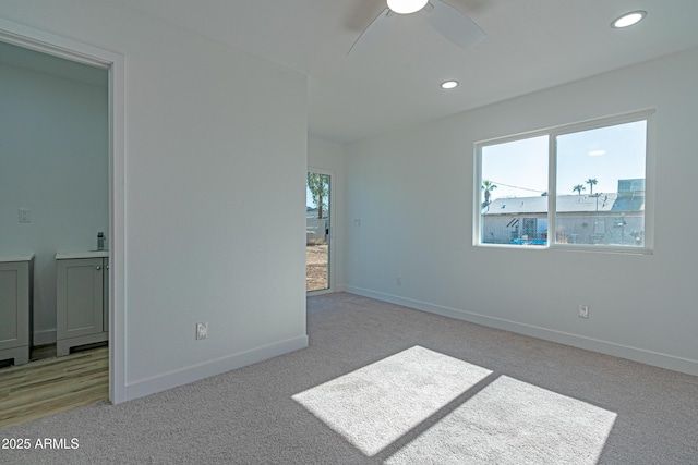 empty room featuring ceiling fan and light colored carpet