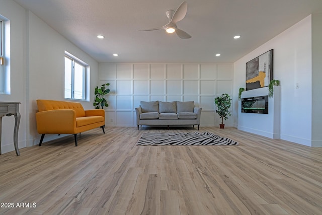 living room with light hardwood / wood-style floors and ceiling fan