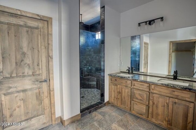 bathroom featuring double vanity, stone finish flooring, a sink, and a shower stall