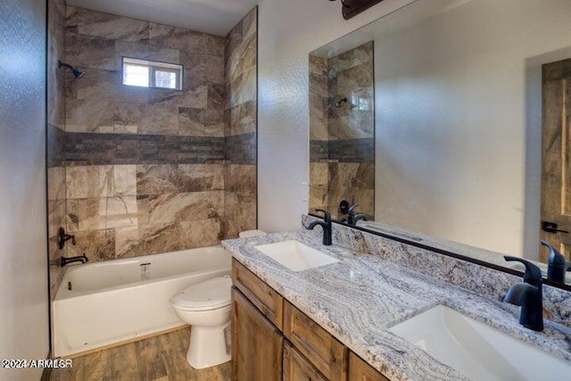 full bathroom with vanity, toilet, tiled shower / bath combo, and hardwood / wood-style floors