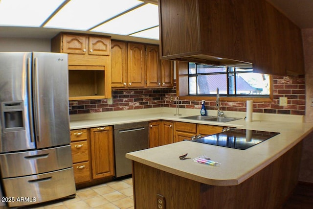 kitchen featuring sink, light tile patterned floors, kitchen peninsula, stainless steel appliances, and backsplash