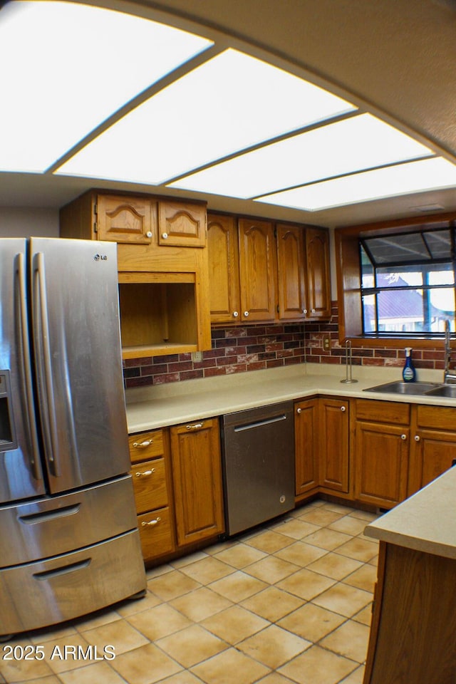 kitchen featuring sink, stainless steel fridge with ice dispenser, light tile patterned floors, dishwashing machine, and backsplash