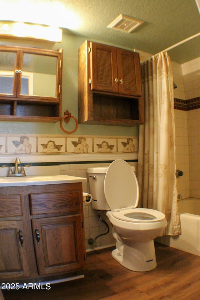 full bathroom with shower / tub combo with curtain, toilet, a textured ceiling, vanity, and hardwood / wood-style flooring