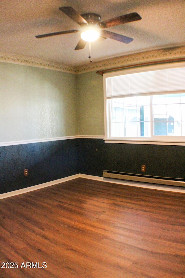 spare room featuring ceiling fan, wood-type flooring, a textured ceiling, and baseboard heating