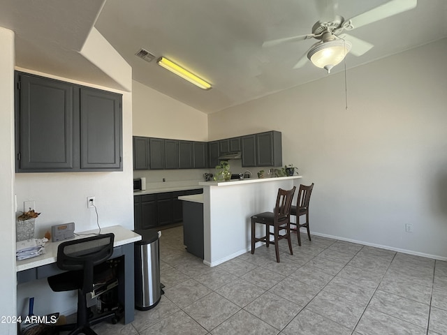 kitchen with kitchen peninsula, a kitchen breakfast bar, vaulted ceiling, ceiling fan, and light tile patterned flooring