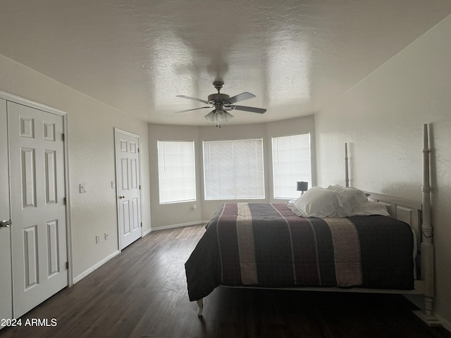 bedroom featuring ceiling fan, dark hardwood / wood-style flooring, and a textured ceiling