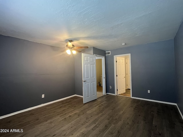 interior space featuring ceiling fan, dark hardwood / wood-style floors, and a textured ceiling