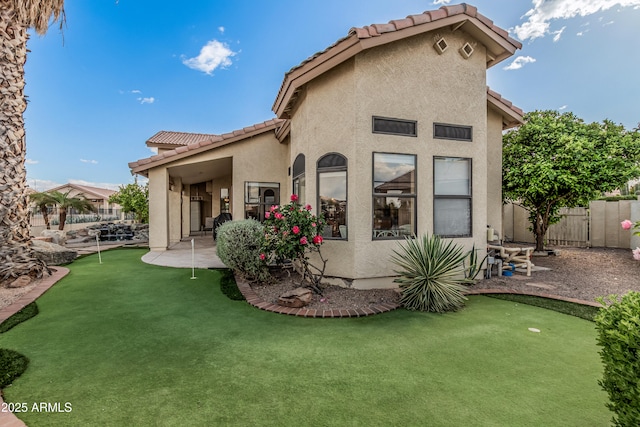 2535 N Pinnule Cir, Mesa, AZ 85215 - back of property with a putting green, a tiled roof, stucco siding, and fence