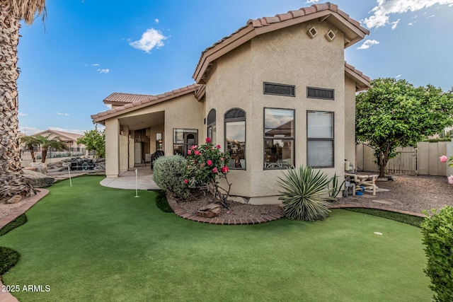 2535 N Pinnule Cir, Mesa, AZ 85215 - back of property featuring a putting area, a tiled roof, stucco siding, and fence