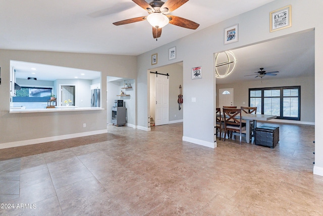 living room with a barn door, ceiling fan, and lofted ceiling