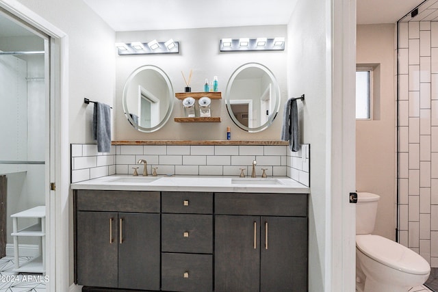 bathroom featuring vanity, toilet, and backsplash