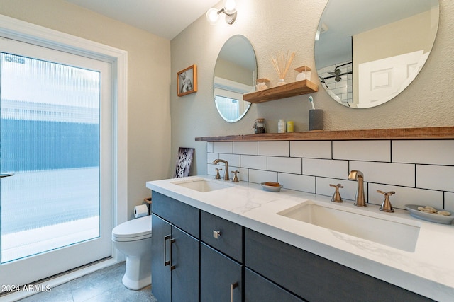 bathroom featuring tile patterned flooring, toilet, a wealth of natural light, and tasteful backsplash