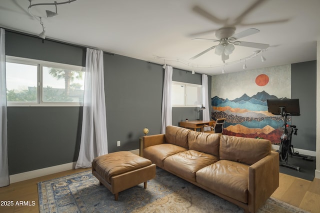 bedroom with multiple windows, wood-type flooring, and track lighting