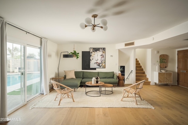 living room with hardwood / wood-style floors and a notable chandelier