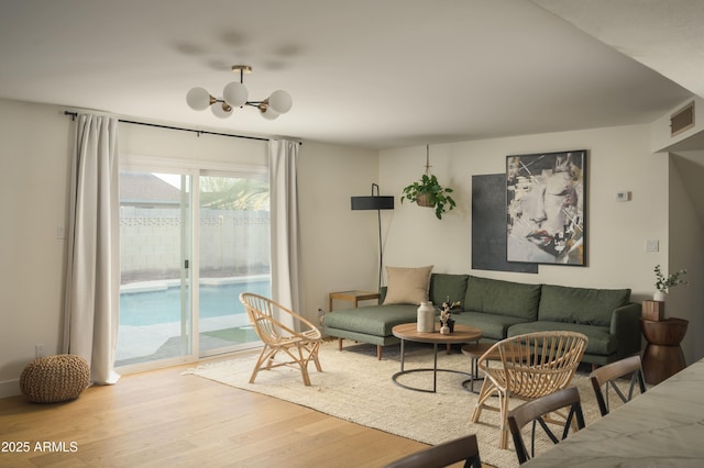 living room with a notable chandelier and light hardwood / wood-style floors