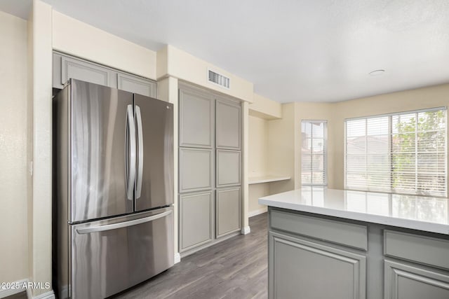 kitchen featuring freestanding refrigerator, gray cabinets, and a wealth of natural light