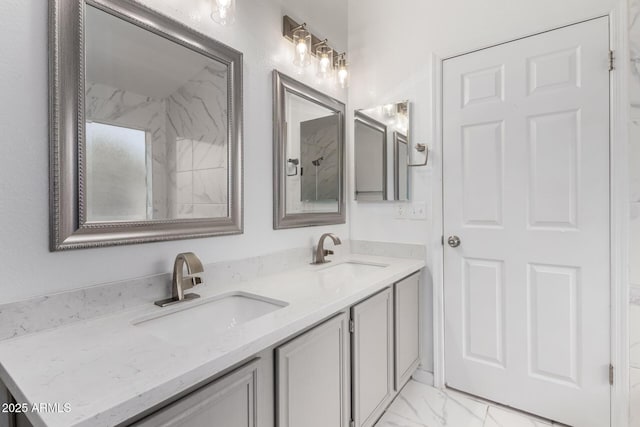 bathroom with marble finish floor, double vanity, and a sink
