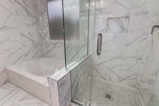 full bath featuring marble finish floor, a marble finish shower, and a garden tub