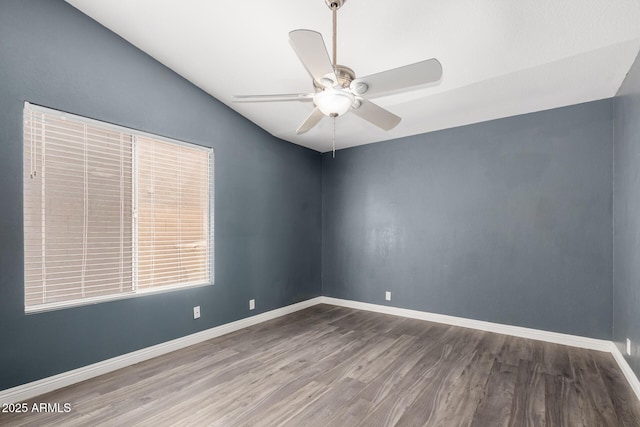 empty room with baseboards, wood finished floors, and a ceiling fan