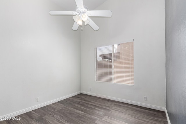 spare room with baseboards, vaulted ceiling, ceiling fan, and dark wood-style flooring