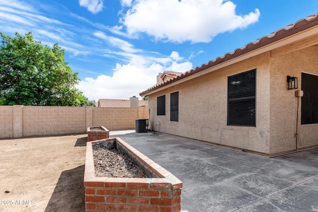view of patio with a fenced backyard and central AC unit