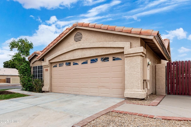 view of front of home featuring a tile roof, driveway, stucco siding, and an attached garage