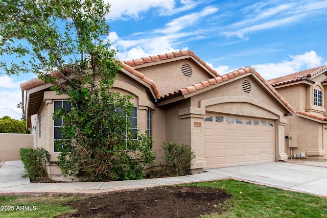 view of front of home featuring driveway, stucco siding, a garage, and a tiled roof