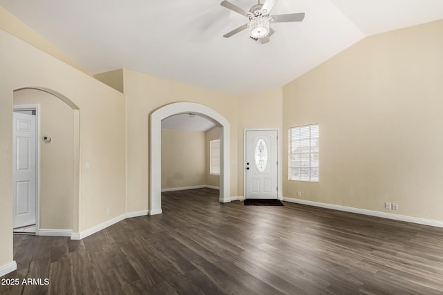 entrance foyer featuring a ceiling fan, arched walkways, dark wood-style floors, and lofted ceiling