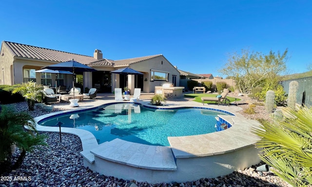 view of pool with exterior kitchen, a fenced in pool, a patio, and fence