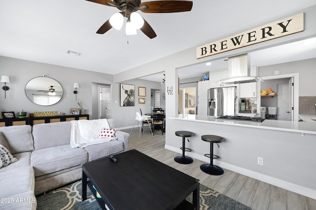 1615 E Roma Ave, Phoenix, AZ 85016 - living area featuring a ceiling fan, light wood finished floors, and baseboards